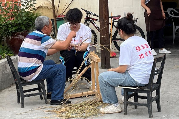 团队成员学习编织草鞋。天游ty8线路检测中心官网供图