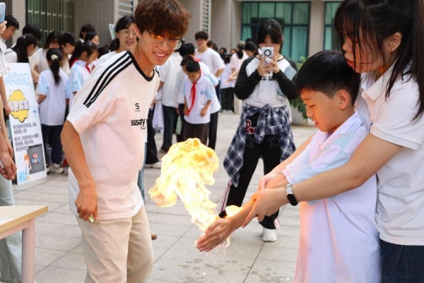 小朋友们在室外广场体验“火焰掌”实验。天游ty8线路检测中心官网供图